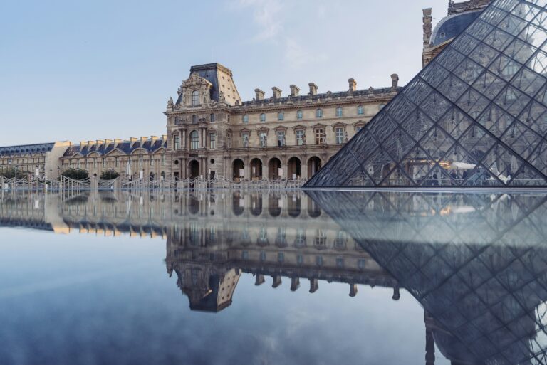 Vista iconica della piramide e del Museo del Louvre riflessi nell'acqua. Prenota i tuoi biglietti e le visite guidate al Museo del Louvre - tramite My Top Tour.